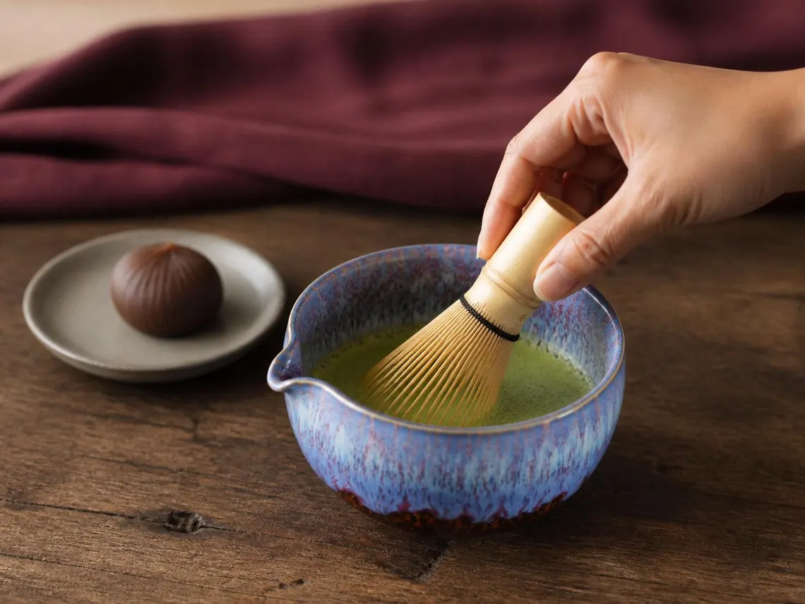 Priprema matcha čaja u ručno rađenoj keramičkoj posudi sa bambusovom metlicom